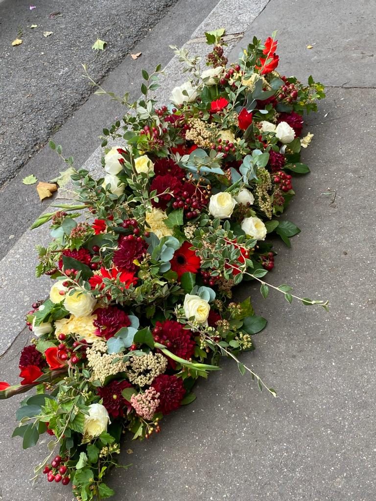 Composition de deuil : roses rouges et fleurs blanches